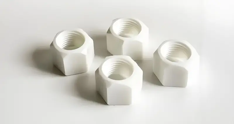 Four white hexagon nuts on a white background