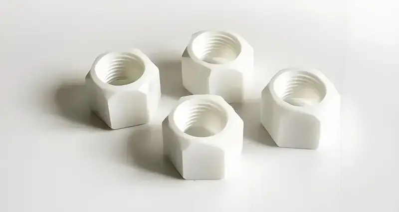 Four white hexagon nuts on a white background