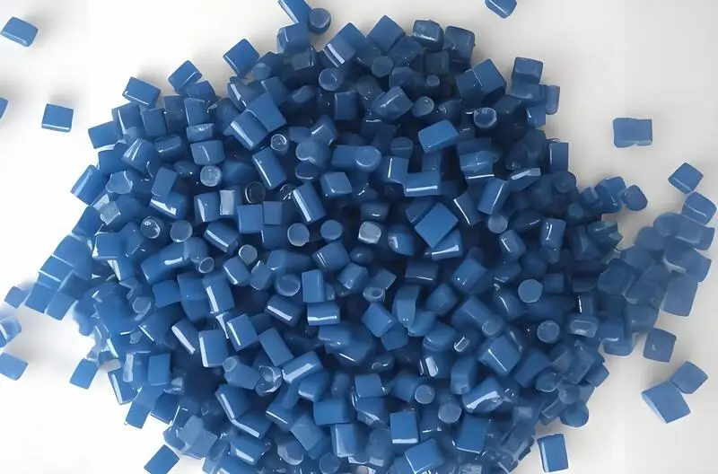 Un montón de gránulos azules de polipropileno (PP) para moldeo por inyección sobre fondo blanco.