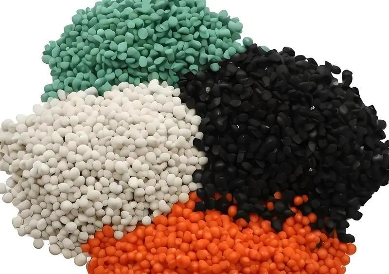 Mucchi di pellet colorati per lo stampaggio a iniezione di plastica su sfondo bianco