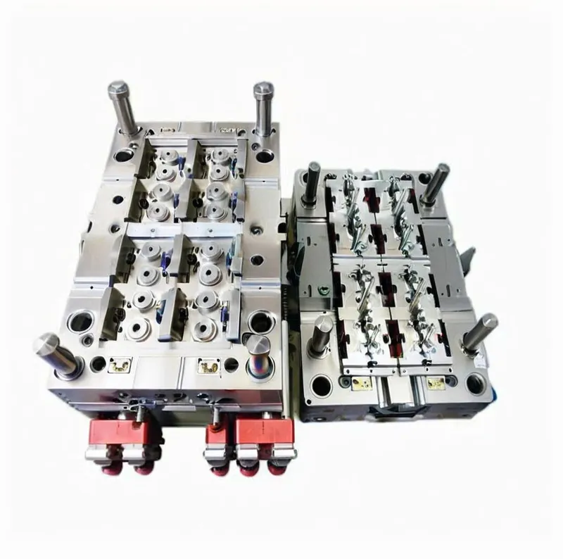 A metallic injection molding die with complex components and red connectors.