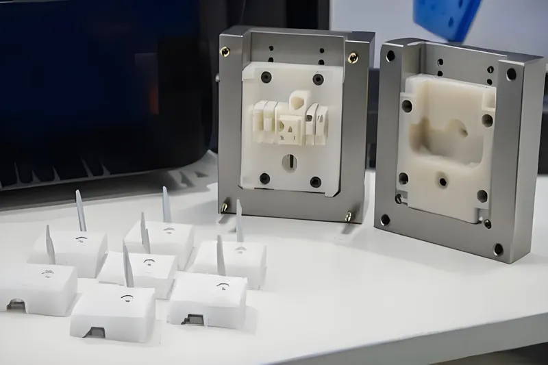Injection molding tools and sample pieces on a table.