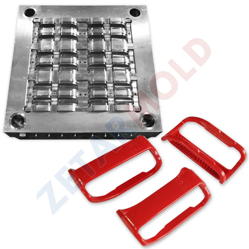 An industrial metal mold with red plastic parts next to it.