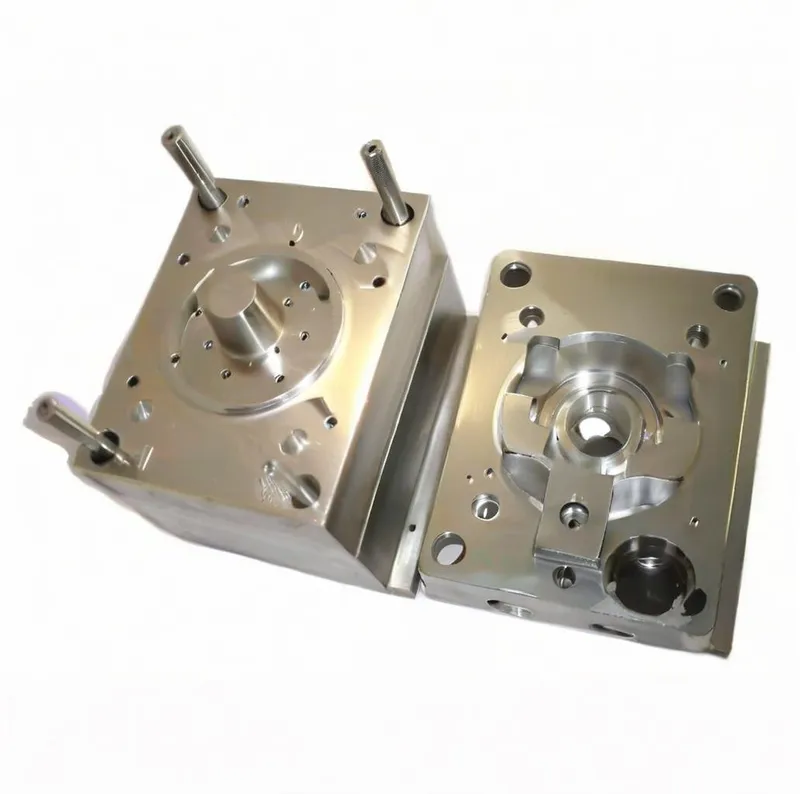 Two metallic parts of an industrial mold with various holes and protrusions.