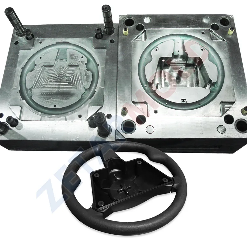 An image showing a metal mold used for manufacturing a steering wheel, with the completed steering wheel placed in front.