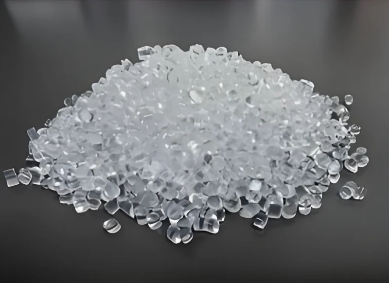 暗い表面に散らばった透明なプラスチックペレットの山。