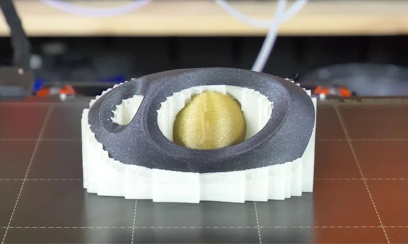 Objeto impreso en 3D con una estructura de soporte compleja, que muestra un diseño complejo y una fabricación de precisión.