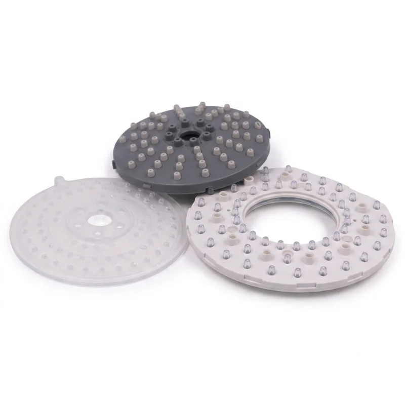 Three plastic injection molded shower head parts in white, transparent, and black.