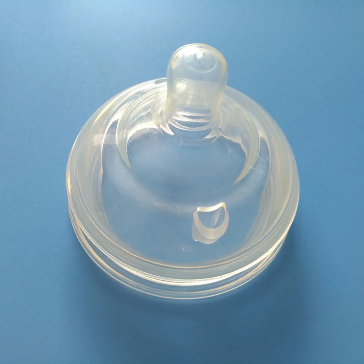 Clear silicone baby bottle nipple resting on a blue surface showcasing its smooth and transparent design.